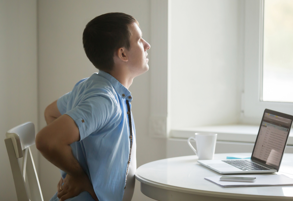 Homme à son poste de travail qui à mal au dos