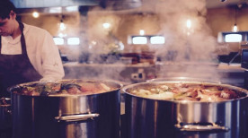 un homme qui cuisine avec un tablier de cuisine