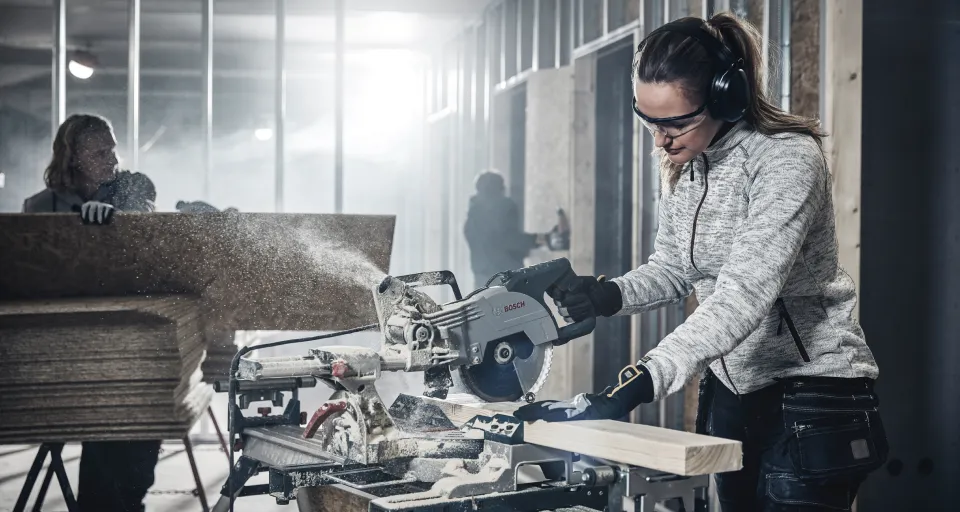Femme avec un casque en train de scier